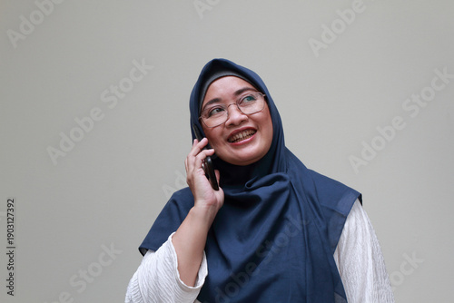 Konstfotografi An Asian Muslim lady smiling while on call. Happy expression.