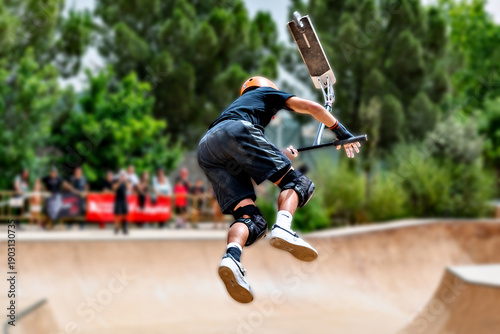 Young man practicing Scootering (Freestyle Scootering) at the SkatePark in Igualada, Barcelona, ​​Spain
