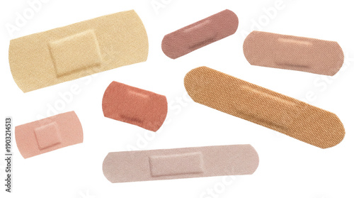 assortment of adhesive bandages in various skin tones and sizes, scattered on a neutral background for first aid and wound care.