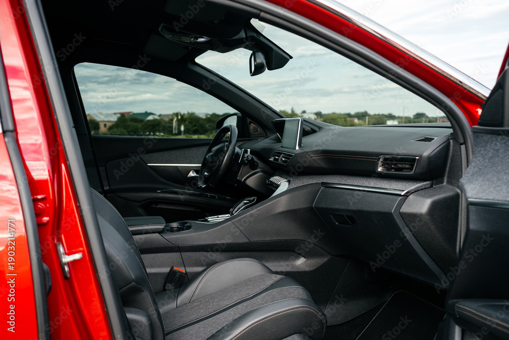 Fototapeta premium Interior details. Modern black car interior, leather steering wheel, climate control, large navigation system screen.