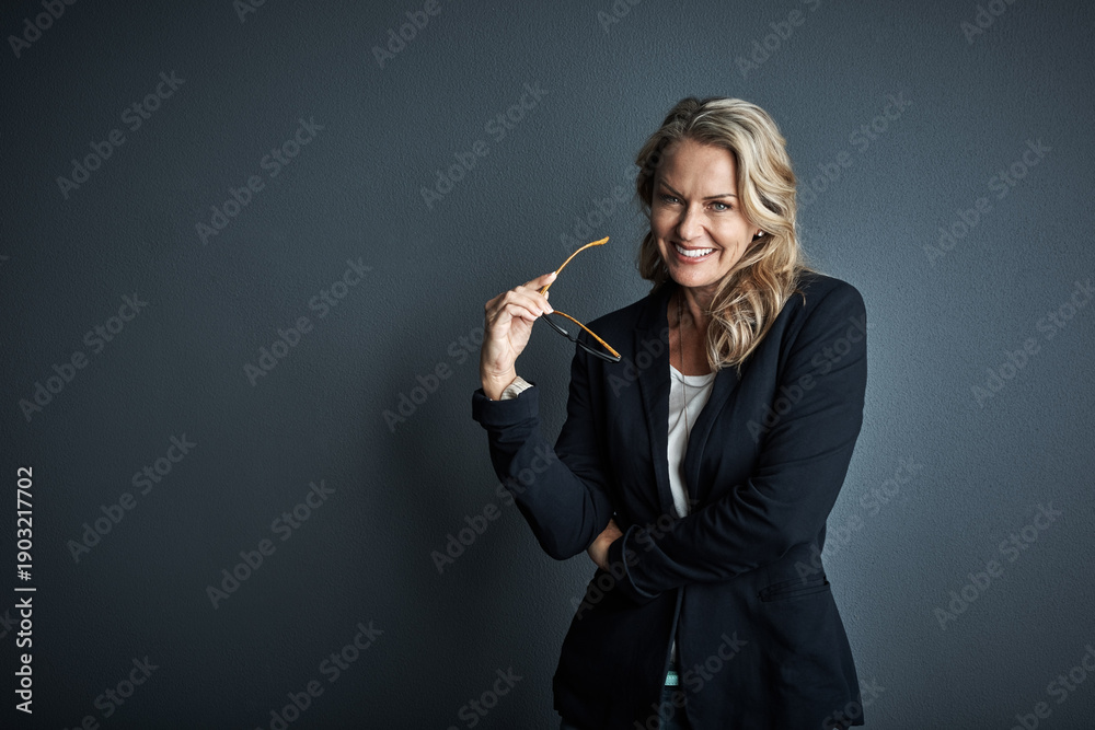 Obraz premium Portrait, businesswoman and happy in studio with glasses, confidence and pride for finance career. Smile, mature person and financial officer with spectacles, ambition and space on dark background.