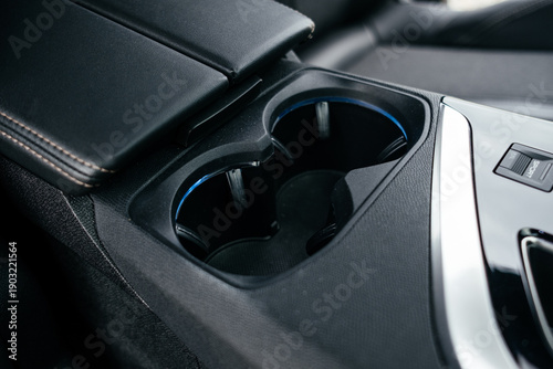 Interior details. Modern black car interior, leather steering wheel, climate control, large navigation system screen.