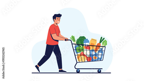 Happy young man in red shirt pushing shopping cart full of fresh vegetables and groceries in supermarket aisle.