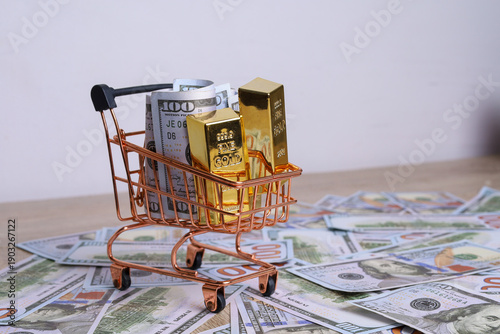 Fotografie Gold Bars and US Dollars in Miniature Shopping Cart
