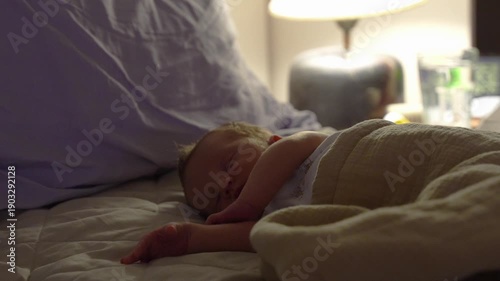newborn baby sleeping on a bed at night