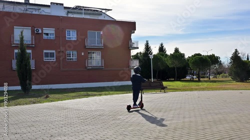 Young boy riding an electric scooter in a park