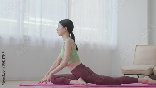 Asian Woman Practicing Yoga Pose in Natural Light at Home