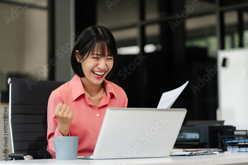Foto Overjoyed Asian woman celebrates a financial bonus