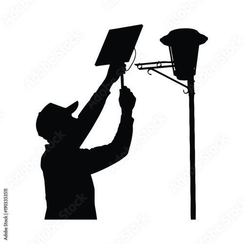 Black silhouette of a man installing a security camera installation technician