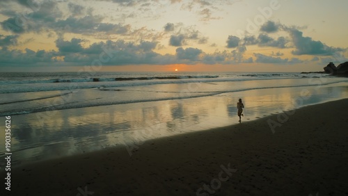 Wallpaper Mural Person running along wet sand of Ostional beach with waves gently washing ashore. Torontodigital.ca