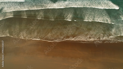 Wallpaper Mural Aerial top view of ocean waves forming white foam patterns on dark sandy beach. Torontodigital.ca