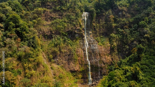 Wallpaper Mural Tall waterfall cascading down rocky cliff in lush green jungle of Costa Rica. Torontodigital.ca