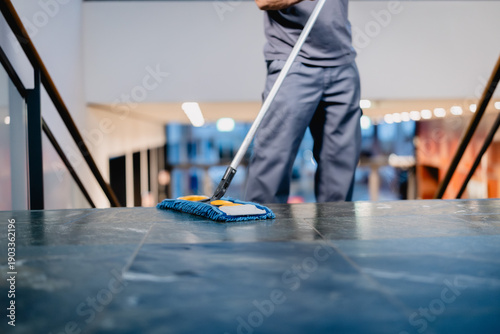 Reinigungskraft wischt die Treppe