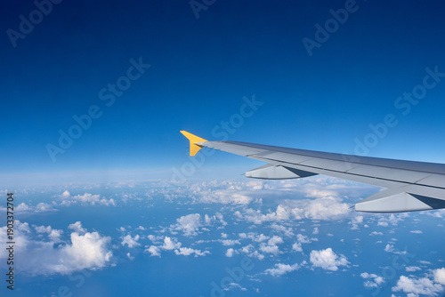 Foto Airplane wing cutting through the airspace above an endless horizon of cottony c