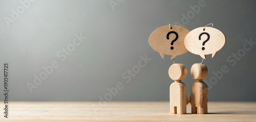 Two wooden figures stand with question marks above heads representing doubt and confusion. They symbolize a team needing solutions for complex problems and seeking answers together.