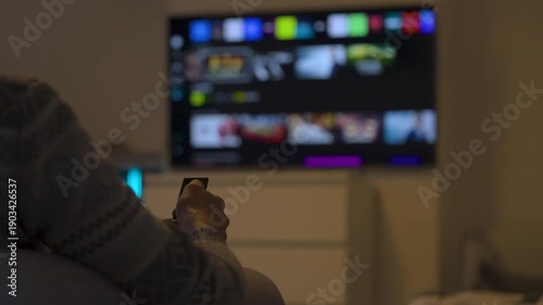 Watching streaming tv with remote in cozy living room