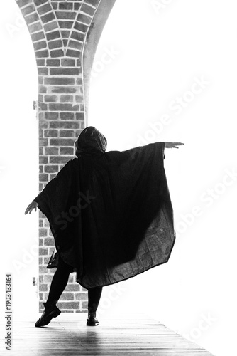 Foto Silhueta de pessoa vestida com capa de chuva.