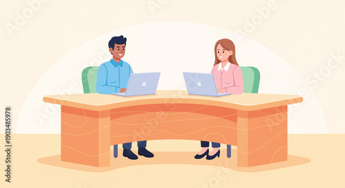 Two colleagues work collaboratively at their laptops across a shared desk