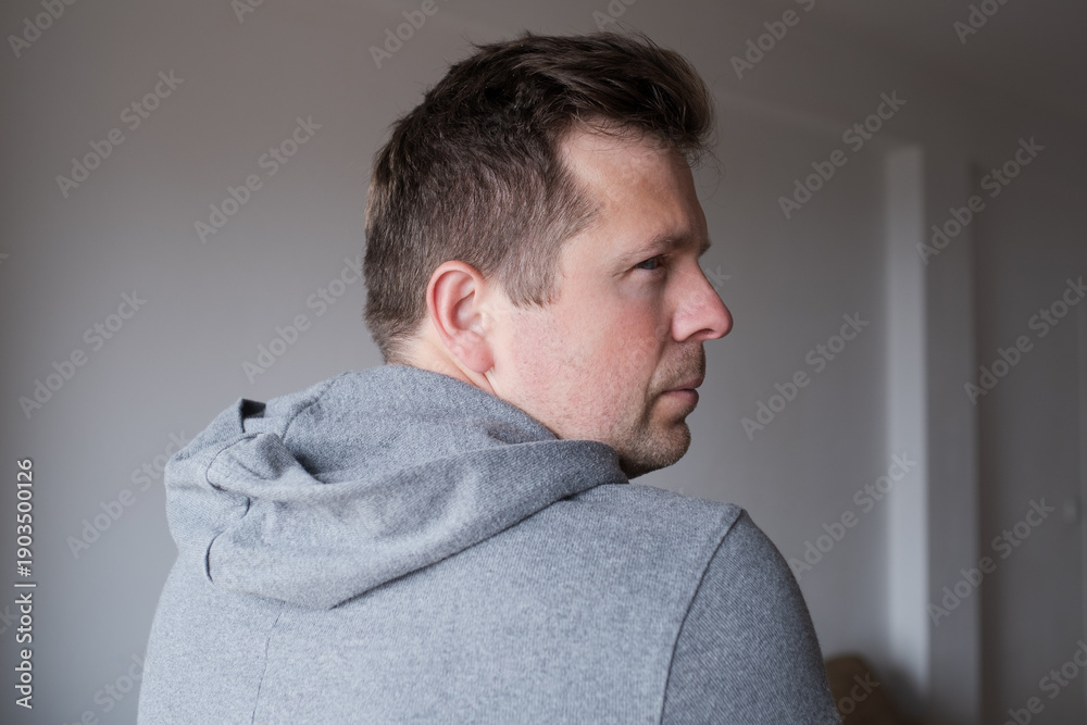 Fototapeta premium Offended man turning his back and looking back over his shoulder with resentment