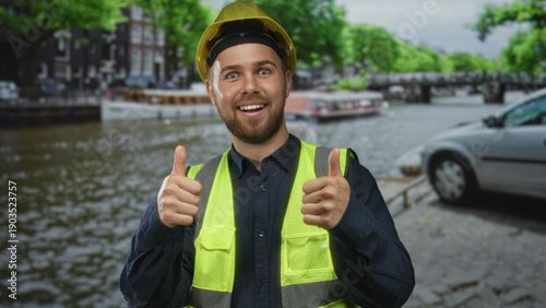 Fotografia Man in yellow hardhat and high visibility vest pointing finger on a street in amsterdam; construction safety confidence