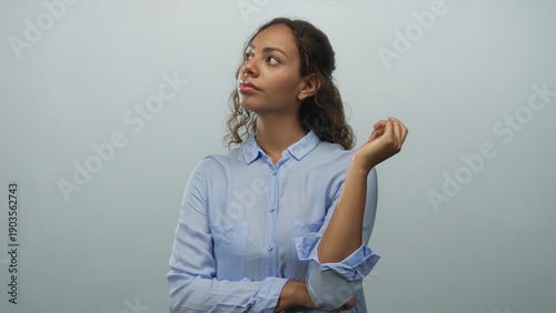 Bild auf Leinwand Woman with raised hand and folded arm posing in studio against pale blue wall; thoughtful reflection
