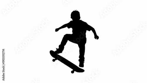 Silhouette of a young boy skateboarding and performing a trick.