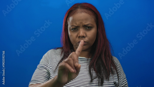 Foto African american woman pointing finger with frown in blue studio to signal refusal; rejection seriousness