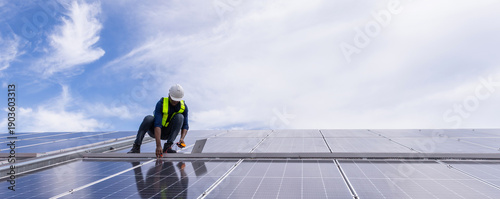Engineer service check installation solar cell on the roof of factory. Engineers walking on roof inspect and check solar cell panel. Engineer working inspection installation solar cell on the roof
