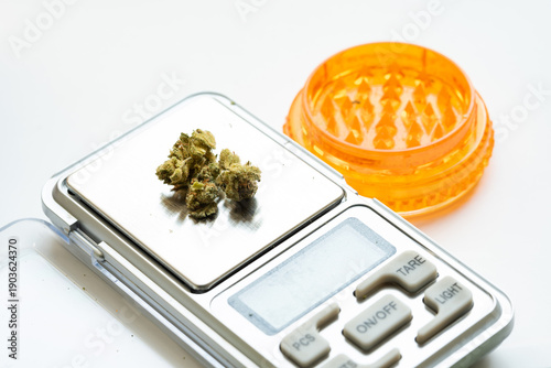 Schilderij op canvas Marijuana buds on digital pocket scale with blank LCD and tare buttons, orange p