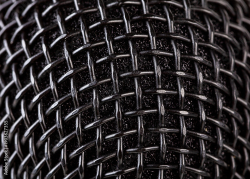 Abstract black microphone grille mesh macro texture, extreme closeup of metal wire weave and foam windscreen, full frame background pattern for audio, music, podcast, studio recording design wallpaper