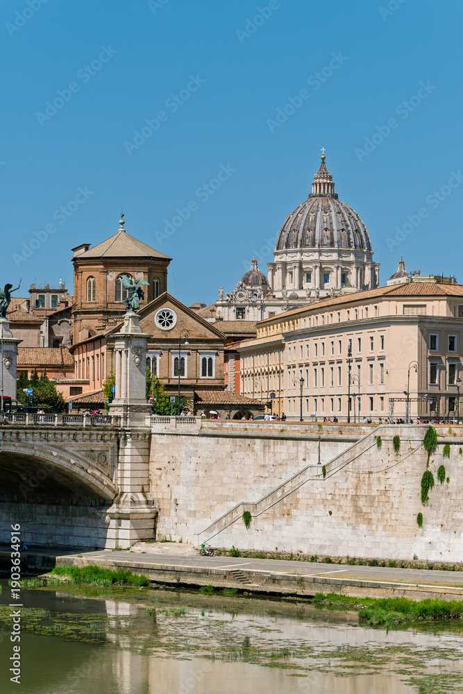 Fototapeta premium Italy - Rome - Tiber River - Sant'Angelo Bridge creates perfect reflection pathway leading to Vatican's iconic basilica dome