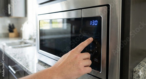 Close up of male hand pressing buttons on modern silver microwave oven in kitchen, domestic appliance promotion