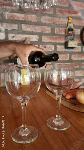 Mature couple pouring red wine while cooking