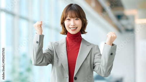 Schilderij op canvas オフィスでガッツポーズを見せる日本人女性社員の成功を表すビジネスシーン, Japanese office worker making a fist pump i