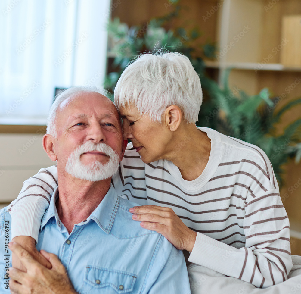 © Lumos sp - Portrait of a happy senior couple embracing talking at home