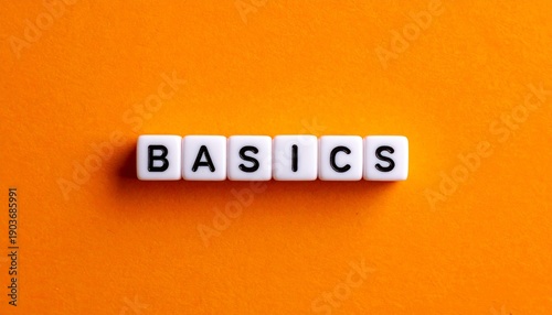 “Basics” Word on White Tiles with Orange Background Showcasing Simplicity, Foundational Concepts, and Educational Design