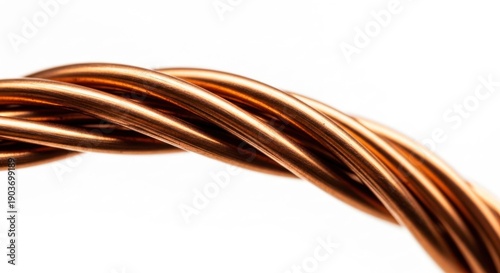 Close-up of twisted, shiny copper wire against a bright white backdrop