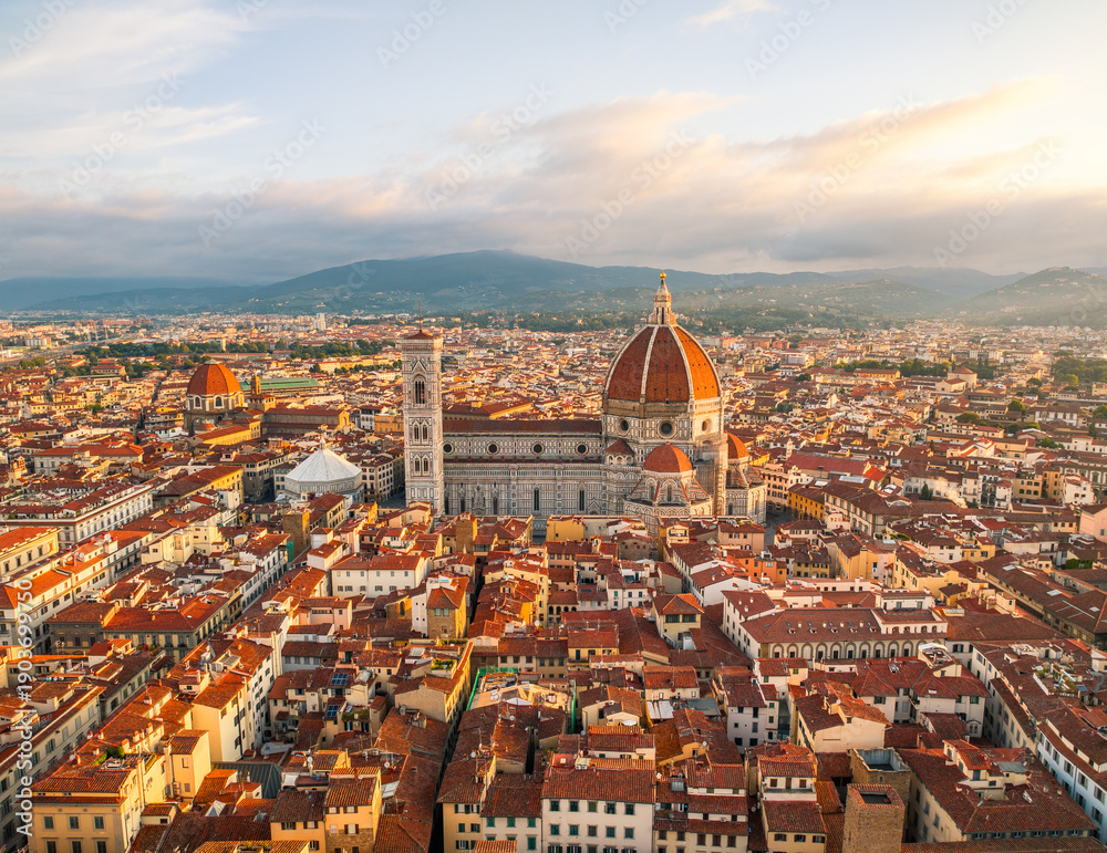 Obraz premium Golden light aerial view of Florence showcasing the Duomo cathedral and historic skyline under warm evening tones in Florence, Italy