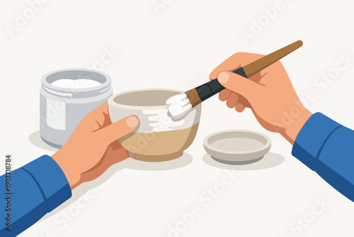 Hands painting ceramic bowl with brush and glaze, illustrating pottery art and craft hobby