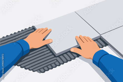 Worker hands installing ceramic floor tile with adhesive during home renovation