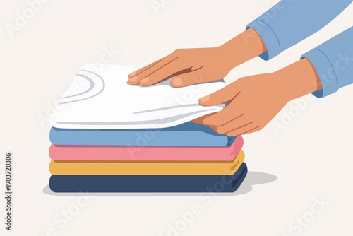 Hands folding clean laundry, stacking colorful clothes for neat organization