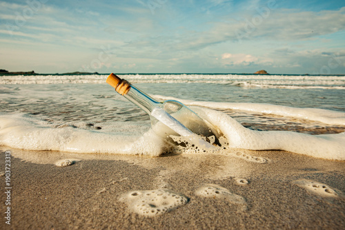 Flaschenpost in einer Welle am Strand
