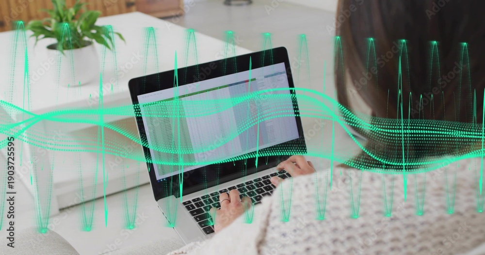 Fototapeta premium Typing Korean woman in knit sweater using laptop spreadsheet on sofa with green waveform overlay
