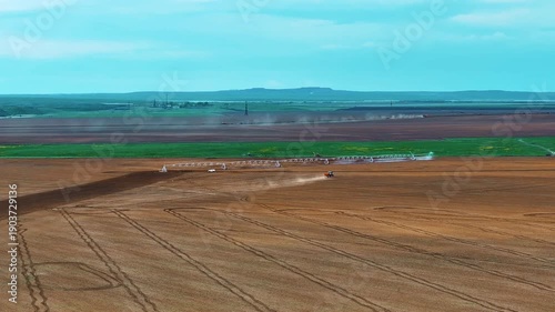 Aerial footage of farmland with an operating center-pivot irrigation system. The panoramic view highlights the vast scale of the fields, modern irrigation methods.