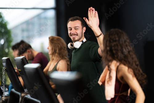 Canvas Print People engaging in fitness activities at a gym with exercise machines in a moder