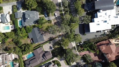 Top-down aerial drone footage of suburban residential neighborhood with homes and tree-lined streets