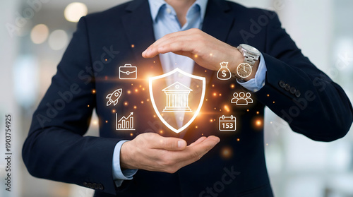 Professional man in suit protecting glowing digital shield with finance and business icons representing data security and financial growth