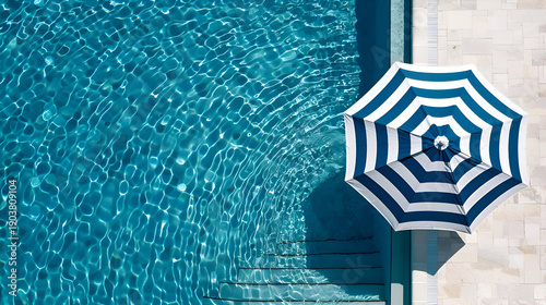 Minimalist aerial view of modern pool with striped umbrella for summer design