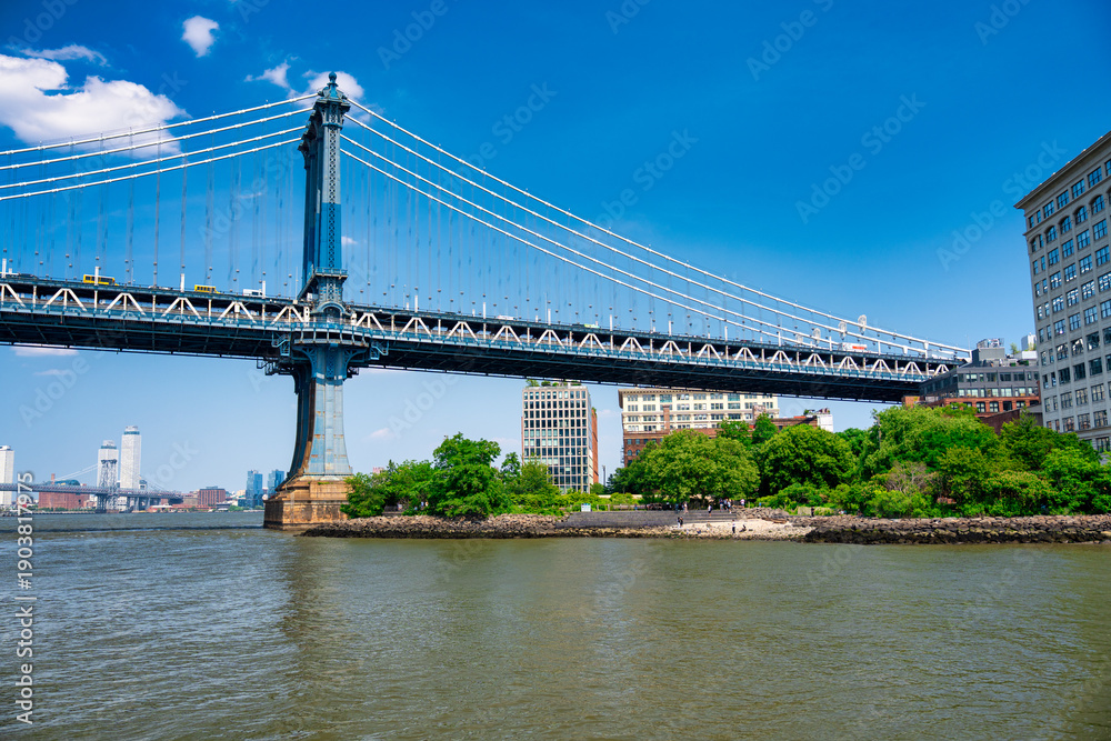 Fototapeta premium Iconic Manhattan Bridge viewed from Brooklyn park during bright summer daylight