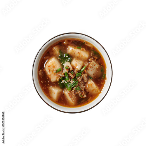 Bowl of Soup With Tofu and Herbs Placed on a Table in a Kitchen Setting Durin...